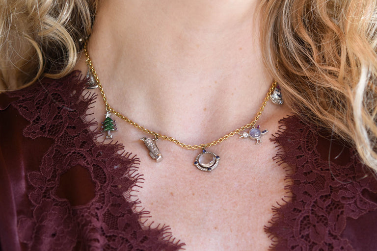 Antique Art Deco holiday-themed multi-gem platinum and 18K gold charm necklace with figural charms, circa 1920 on a model - horizontal