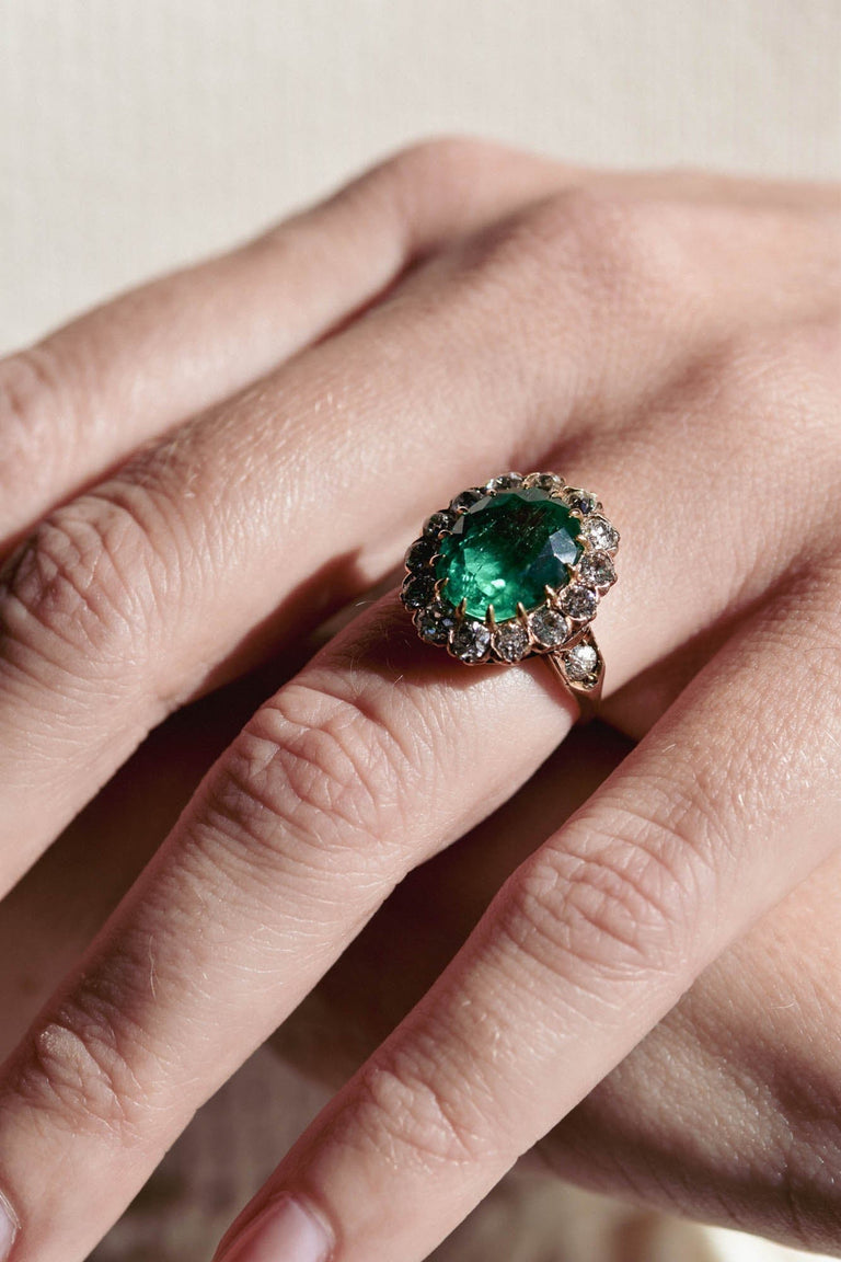 Victorian 4.49 Carat Oval Cut Colombian Emerald & Diamond Cluster Ring on a hand