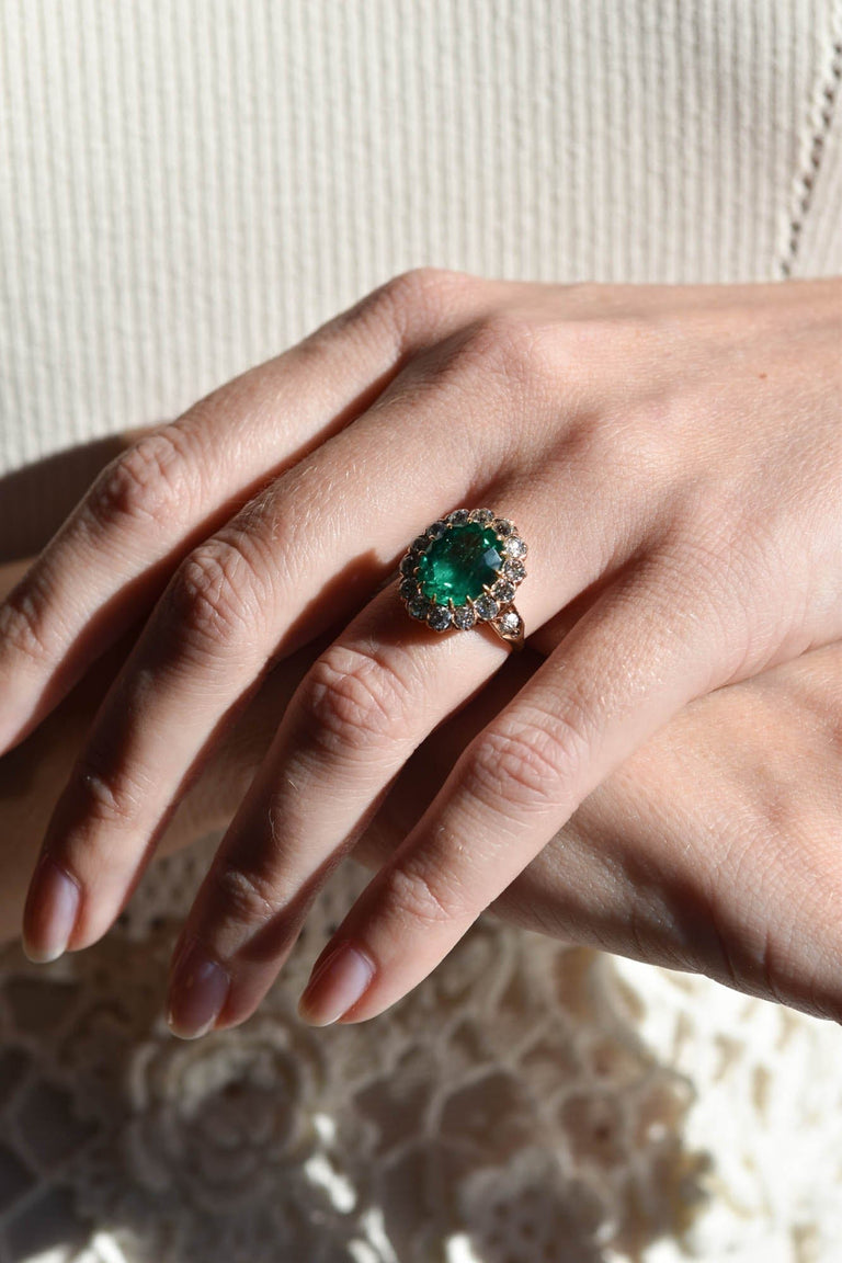 Victorian 4.49 Carat Oval Cut Colombian Emerald & Diamond Cluster Ring on a hand 2