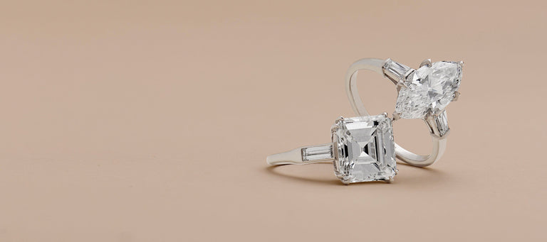 two midcentury engagement rings with a beige background