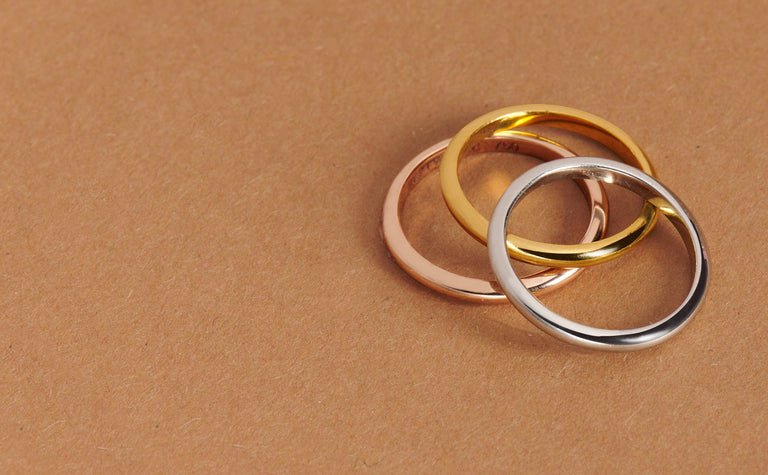 three classic plain wedding bands in platinum, gold and rose gold